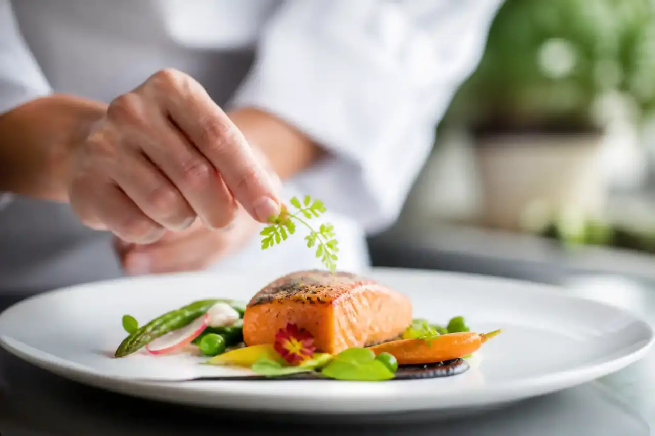 Assiette gastronomique dressée avec élégance dans une ambiance sombre et raffinée